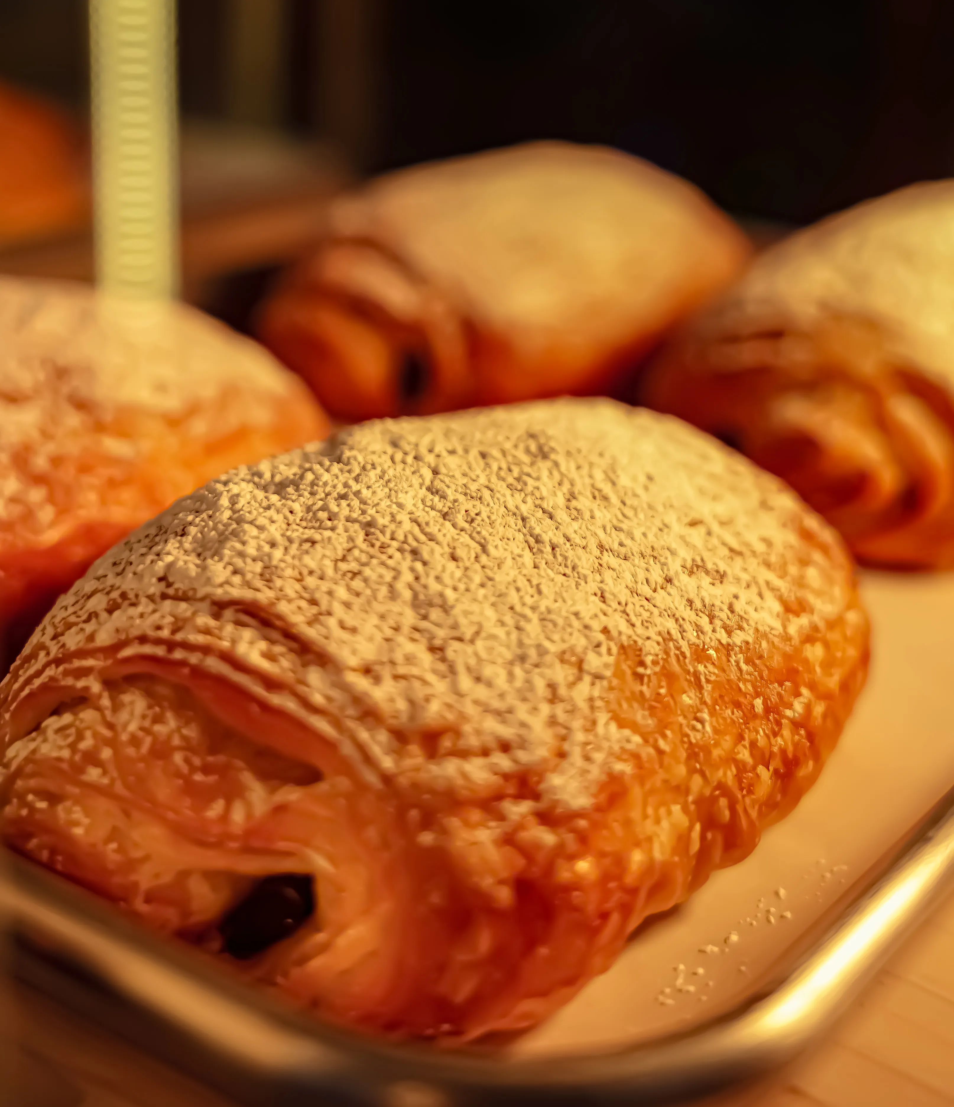 Fresh chocolate croissants dusted with powdered sugar