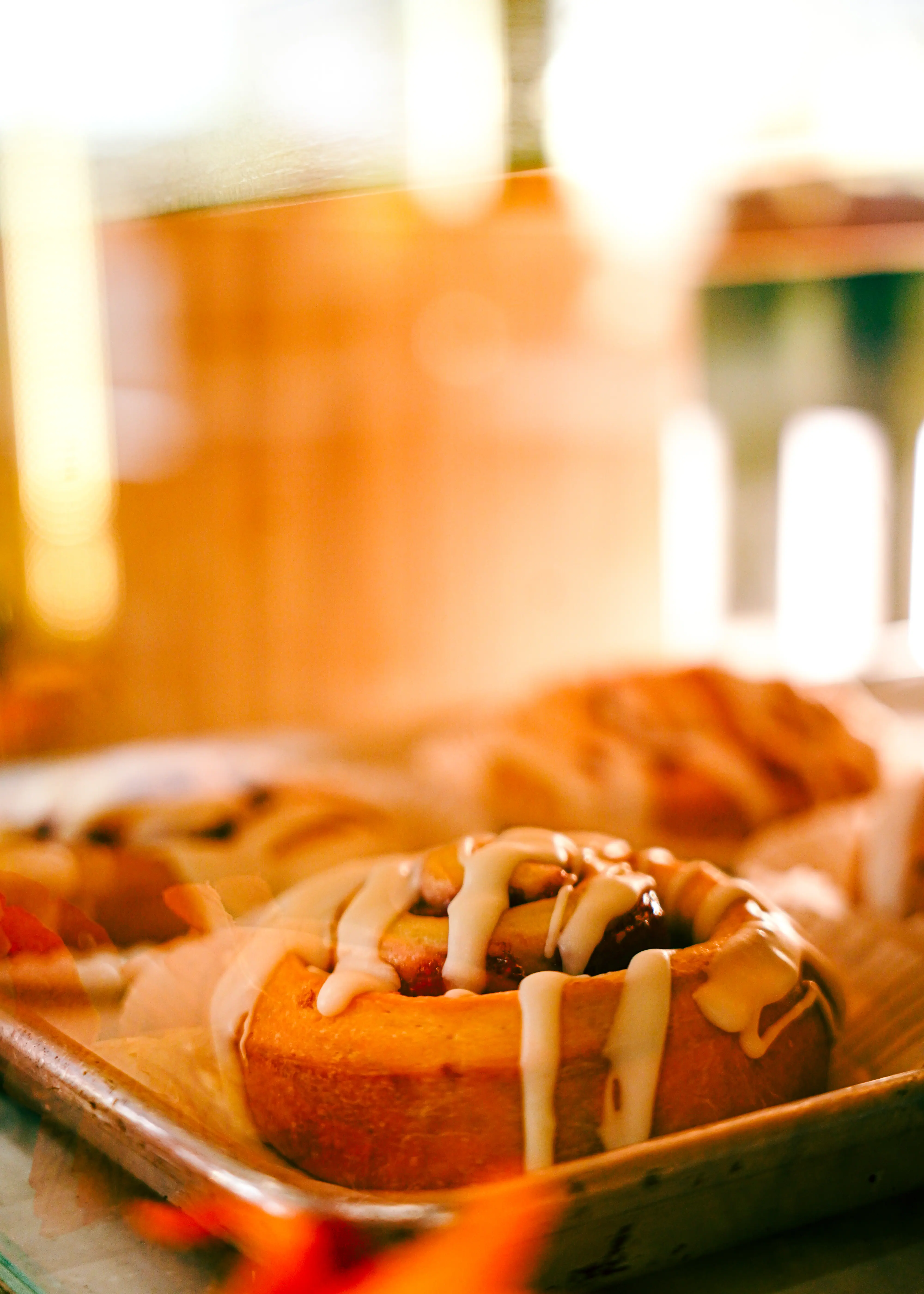 Closeup of a freshly glazed roll inside a pastry case
